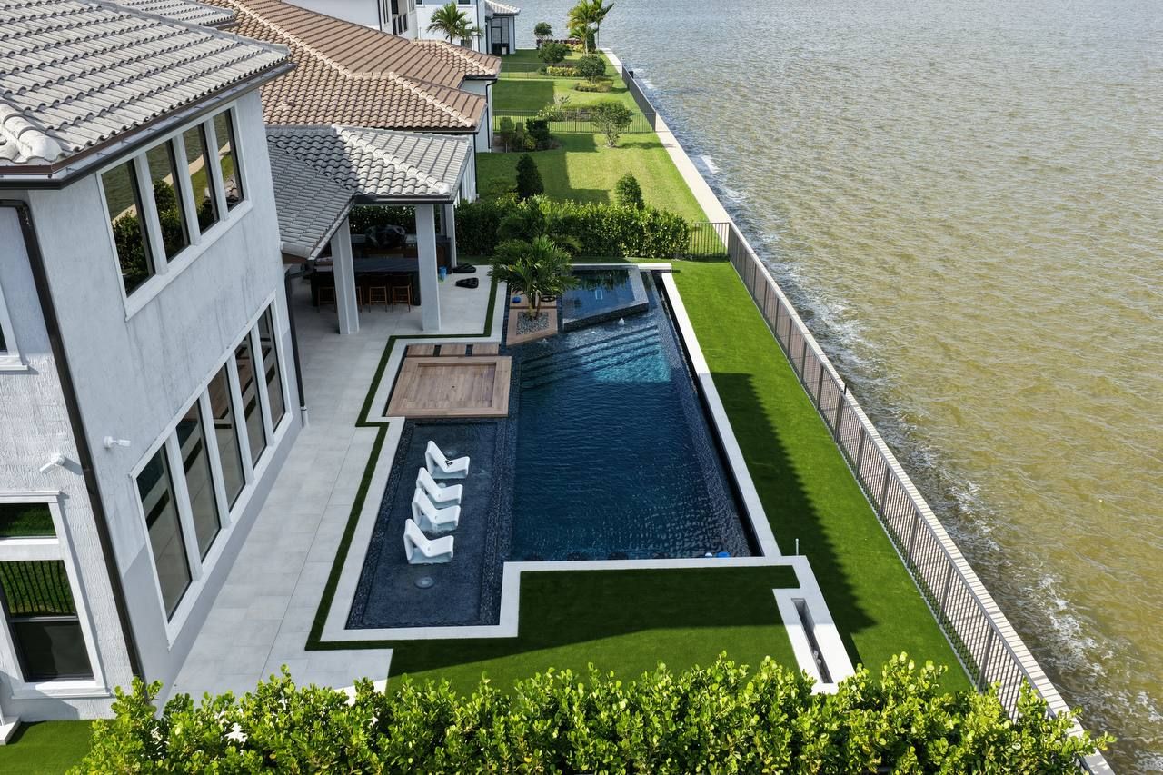 Aerial view of a Master Touch pool with spa beside a lake